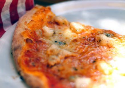 Close-up of a cheese and tomato pizza with a golden crust