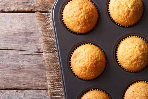 Golden vanilla muffins cooling in a muffin tin